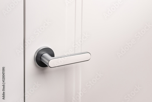 Door handle on white closed doors in modern loft style in interior.
