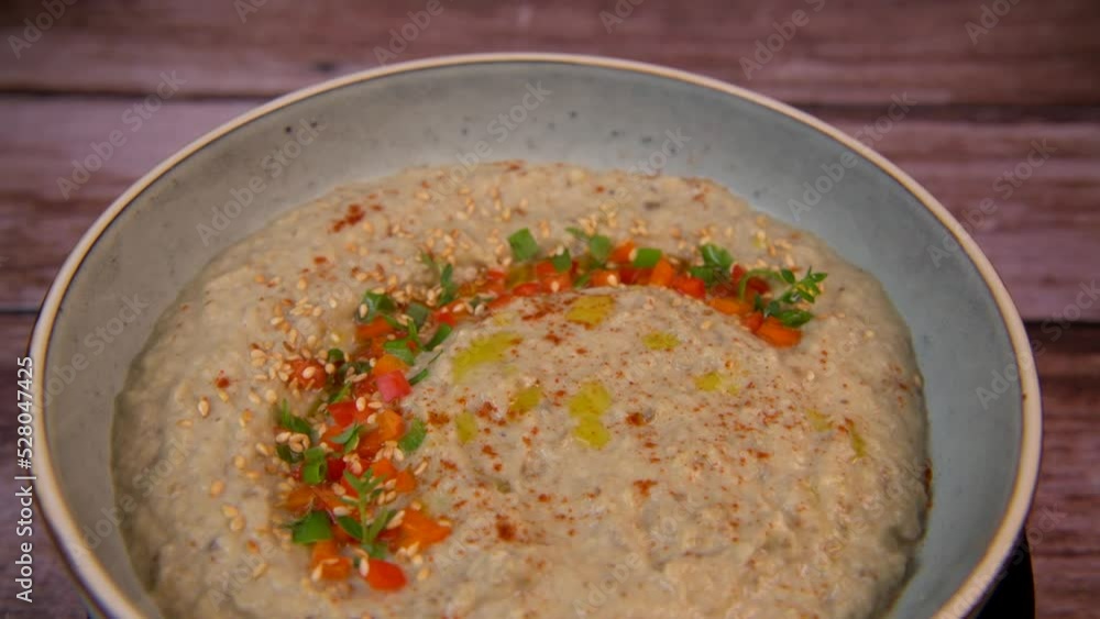 Traditional arabian eggplant dip baba ganoush with herbs and smoked paprika on a wooden background. High quality 4k footage Traditional arabian eggplant dip baba ganoush with herbs and smoked paprika on a wooden background. High quality 4k footage
