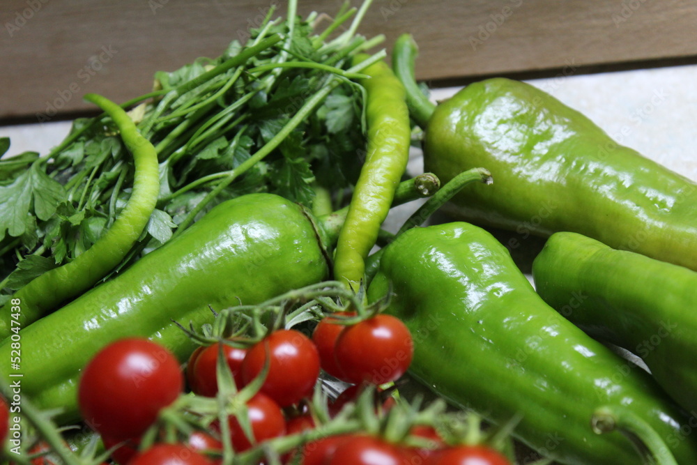 Some tiny cherry tomatoes and green peppers in white plates on wooden concept. Some tiny cherry tomatoes and green peppers in white plates on wooden concept.