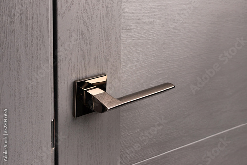 Close up of stylish new metal door knob on modern interior door.