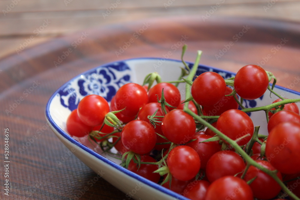 Some tiny cherry tomatoes and green peppers in white plates on wooden concept. Some tiny cherry tomatoes and green peppers in white plates on wooden concept.