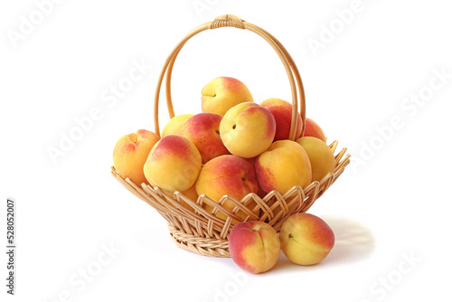 Apricots in wicker basket isolated on white