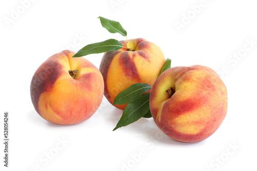 Three peaches with leaves isolated on white