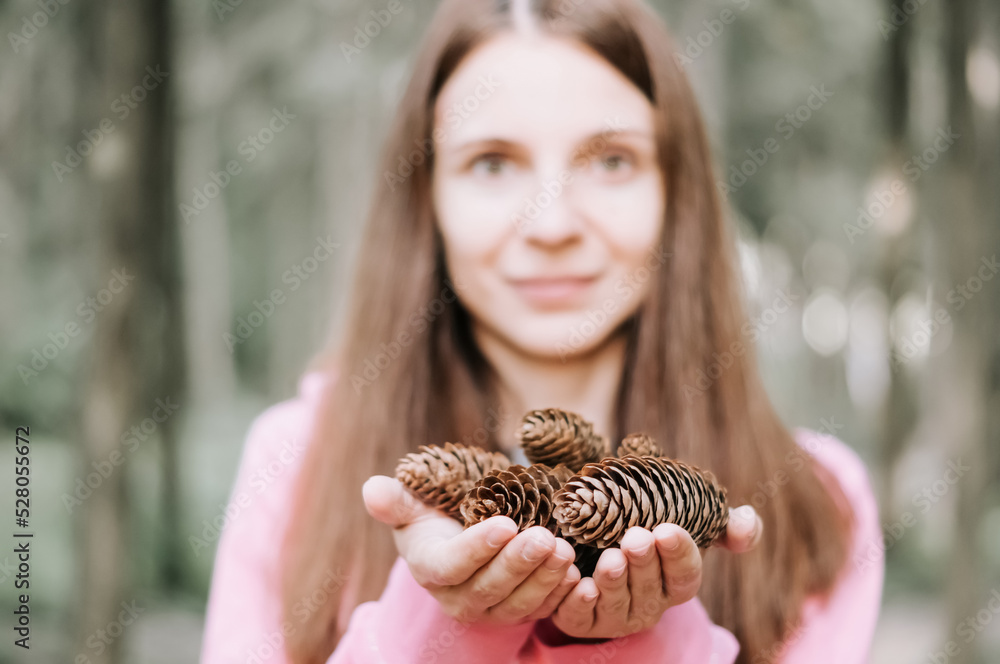 Girl holds fir cones in her hands