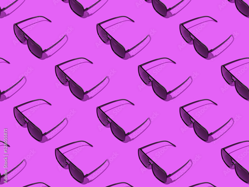 A pattern of beautiful sunglasses on a purple background. A pattern of beautiful sunglasses on a purple background.