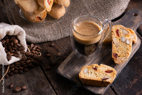 Traditional Italian almond biscuits biscotti served on a wooden board with a cup of aromatic coffee