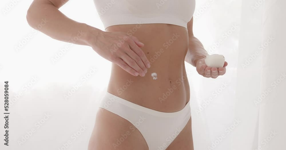 Woman applying moisturiser cream lotion on belly Woman applying moisturiser cream lotion on belly