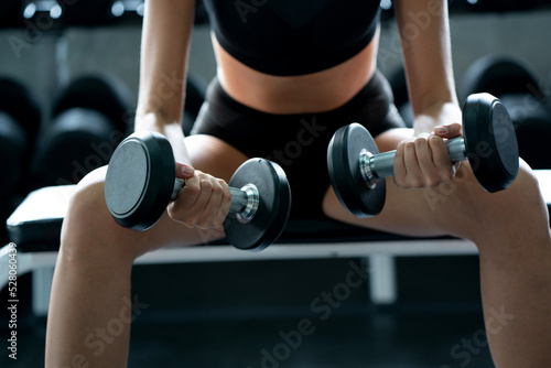 Beautiful Caucasian woman wearing workout clothes Use your arms to lift small dumbbells in the gym. Fat Burning Motivation to have a good body shape. concept sustainable life