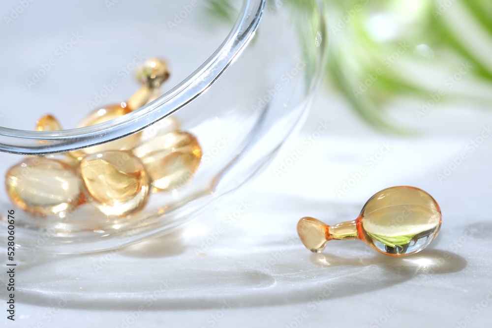 Serum capsules for healthy skin routine. Anti-wrinkle rejuvenation skin treatment. Beauty product presentation. Off white stone marble background. Serum capsules for healthy skin routine. Anti-wrinkle rejuvenation skin treatment. Beauty product presentation. Off white stone marble background.