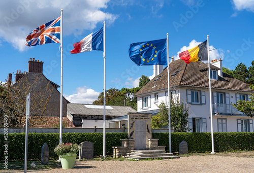 Flags of France, Belgium, Great Britain and the European Union near the memorial plate to the liberators of the city of Merville-Franceville Plage.