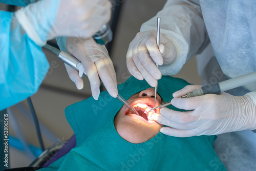 doctor cleaning the teeth patient with ultrasonic tool