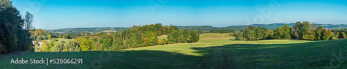 Ultra wide panoramic late summer landscape with idyllic green meadow, trees, forest and hills with clear blue sky, Czech republic, central bohemia