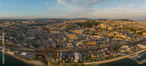 Panoramic aerial view of train line cutting through sprawling coastal town