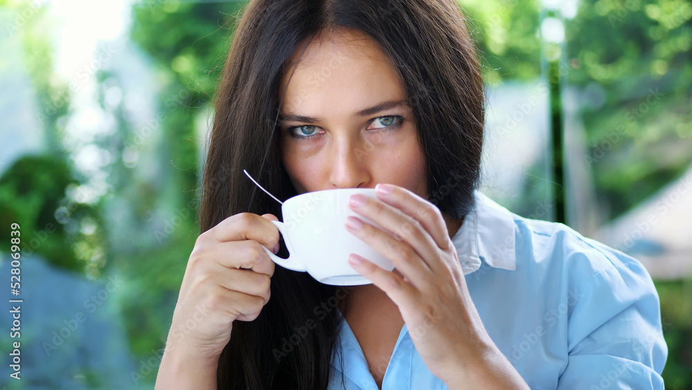 Portrait of pleasant smiling, Happy beautiful real 40 years old Ukrainian woman. a woman drinks tea without taking out a teaspoon. High quality photo Portrait of pleasant smiling, Happy beautiful real 40 years old Ukrainian woman. a woman drinks tea without taking out a teaspoon. High quality photo