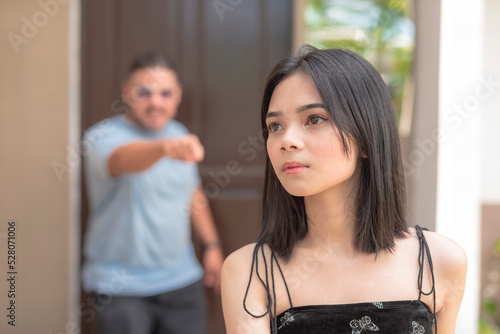 A sad young Asian woman is being scolded by her father early in the morning. photo