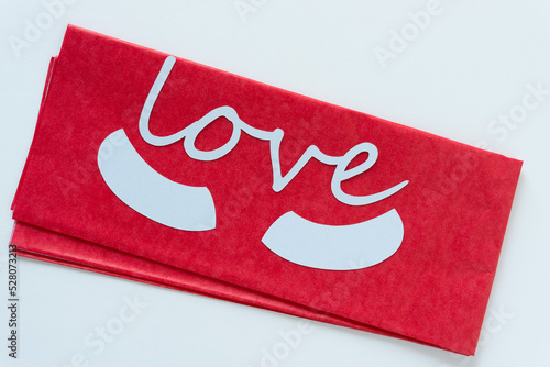 love and parentheses on red tissue and blank paper photo