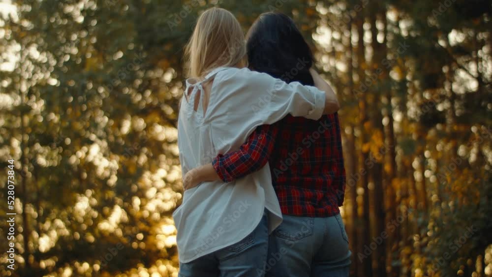 Lesbian couple two women hug and touch each other at sunset in the park. Tender relationship of a homosexual couple Lesbian couple two women hug and touch each other at sunset in the park. Tender relationship of a homosexual couple