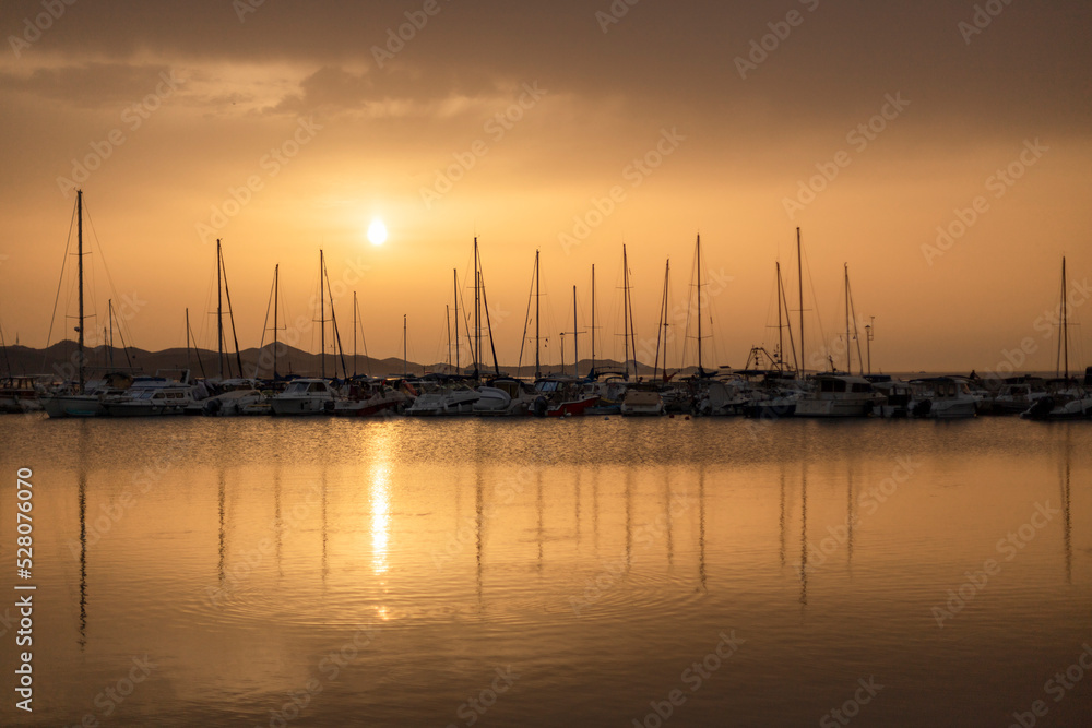 Small harbor with yachts and sail boats in at sunset