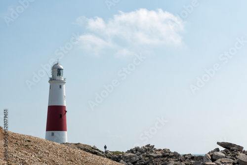 Red and white lighthouse with a person on the side