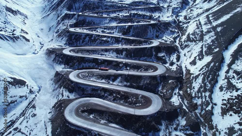 Famous winding road at Andes Mountains. Los Caracoles highway road near Santiago Chile. Snowing scenery. Snow highway road. Winding curves background near Argentina and Chile border. Famous winding road at Andes Mountains. Los Caracoles highway road near Santiago Chile. Snowing scenery. Snow highway road. Winding curves background near Argentina and Chile border.