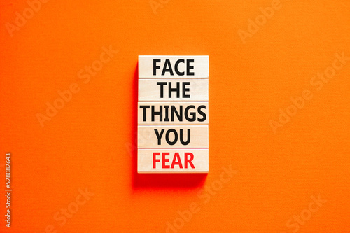 Face the things you fear symbol. Concept words Face the things you fear on wooden blocks on a beautiful orange table orange background. Business and face the things you fear concept. Copy space.