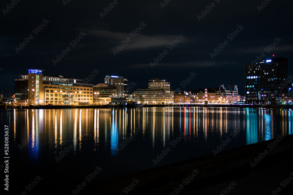 Fototapeta premium Skyline of Malmö Sweden seen from the water with lights reflecting