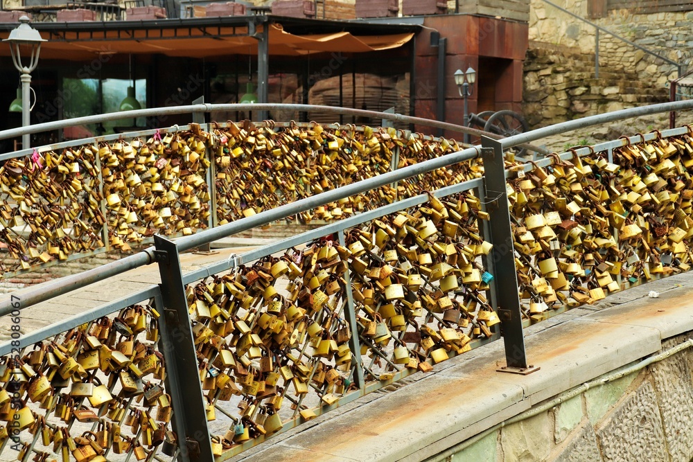A large number of locks on the railing of the bridge symbolizing a strong love union