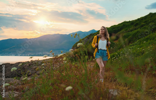 Woman tourist with backpack walking in mountains.