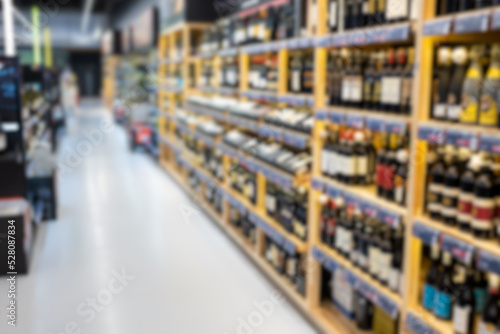 Wallpaper Mural Out of focus photo of wine bottle shelves in store Torontodigital.ca