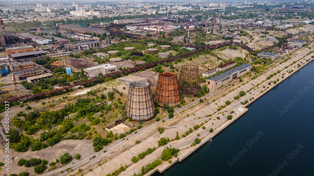 Three cooling towers (power plants), one is under construction on the banks of a large river. The concept of ecology. Water purification and cooling.