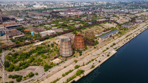 Three cooling towers (power plants), one is under construction on the banks of a large river. The concept of ecology. Water purification and cooling. © Eduard Maslennikov