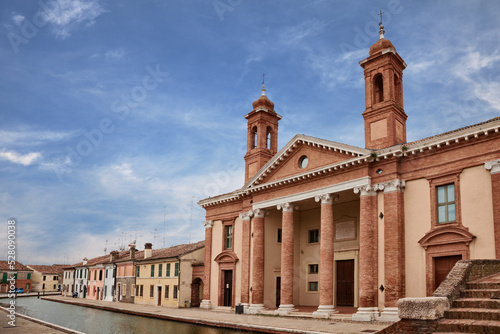 Comacchio, Ferrara, Emilia Romagna, Italy: the ancient hospital Ospedale degli Infermi with church, in neoclassical architecture, at the edge of the canal that crosses the old town photo
