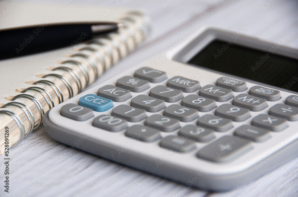 Close up of calculation with blurred background of notebook and pen. Copy space and business concept Close up of calculation with blurred background of notebook and pen. Copy space and business concept