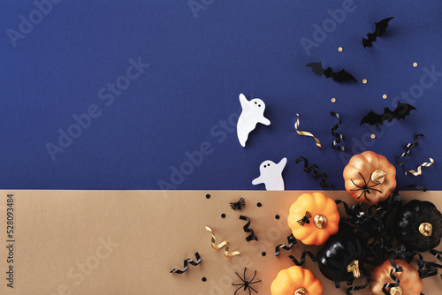 Halloween holiday card with party decorations of pumpkins, bats, ghosts on gold blue background top view. Happy halloween greeting poster in flat lay style.