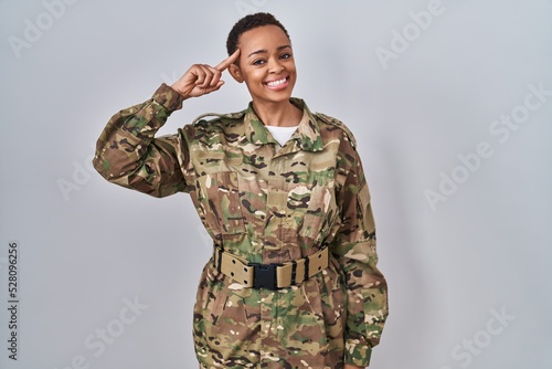 Beautiful african american woman wearing camouflage army uniform smiling pointing to head with one finger  great idea or thought  good memory