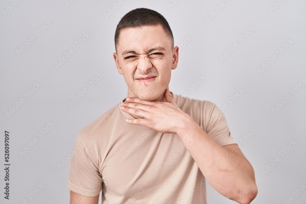 Fototapeta premium Young man standing over isolated background cutting throat with hand as knife, threaten aggression with furious violence
