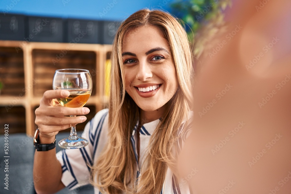 Young blonde woman make selfie by the smartphone drinking champagne at home Young blonde woman make selfie by the smartphone drinking champagne at home