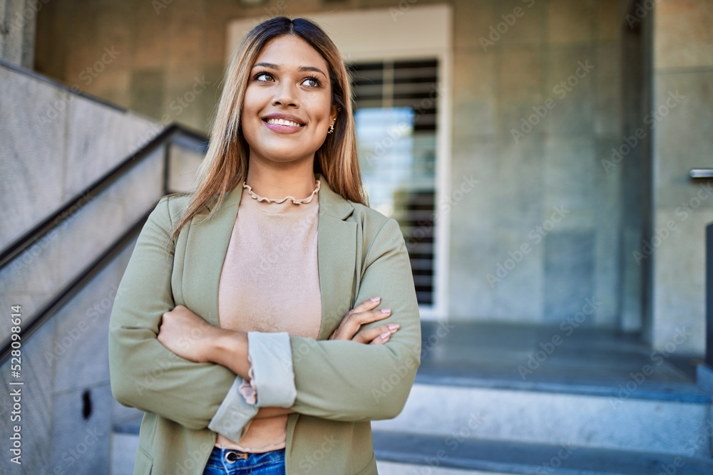 Young latin woman smiling confident at street