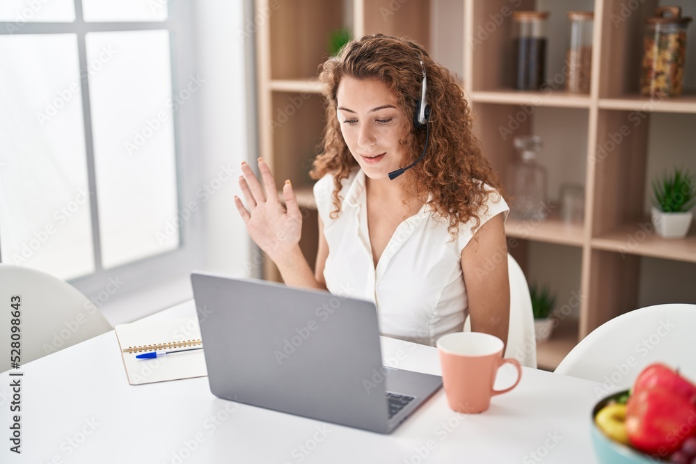 Young caucasian woman wearing call center agent headset working from home looking positive and happy standing and smiling with a confident smile showing teeth Young caucasian woman wearing call center agent headset working from home looking positive and happy standing and smiling with a confident smile showing teeth