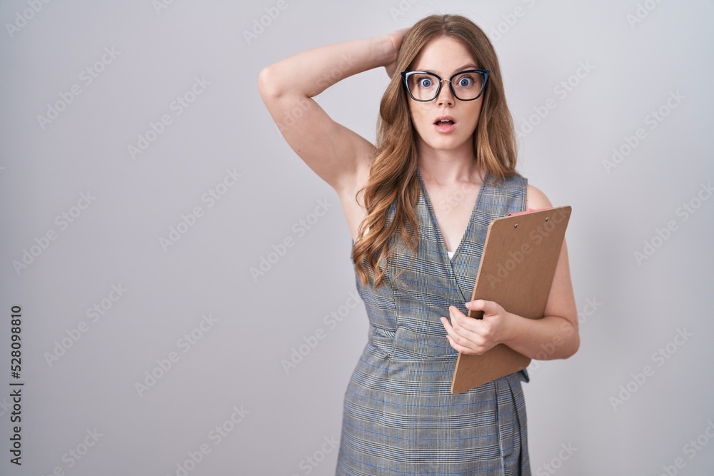 Caucasian woman wearing glasses and business clothes crazy and scared with hands on head, afraid and surprised of shock with open mouth Caucasian woman wearing glasses and business clothes crazy and scared with hands on head, afraid and surprised of shock with open mouth