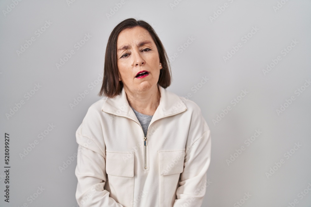 Middle age hispanic woman standing over isolated background looking sleepy and tired, exhausted for fatigue and hangover, lazy eyes in the morning. Middle age hispanic woman standing over isolated background looking sleepy and tired, exhausted for fatigue and hangover, lazy eyes in the morning.