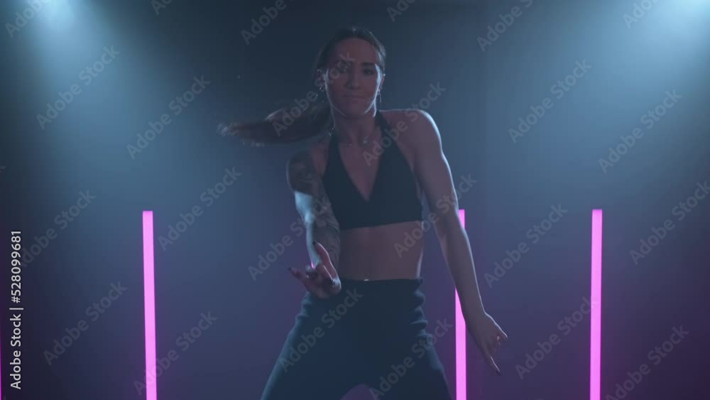 Sensual choreography in smoky studio with beautiful light. Talented woman on dark stage. Graceful female dancing in dark room with spotlights. 4K, UHD