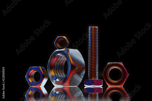 composition of bolts and nuts of different sizes on a black background
