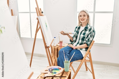 Young artist woman painting on canvas at art studio with a happy and cool smile on face. lucky person.