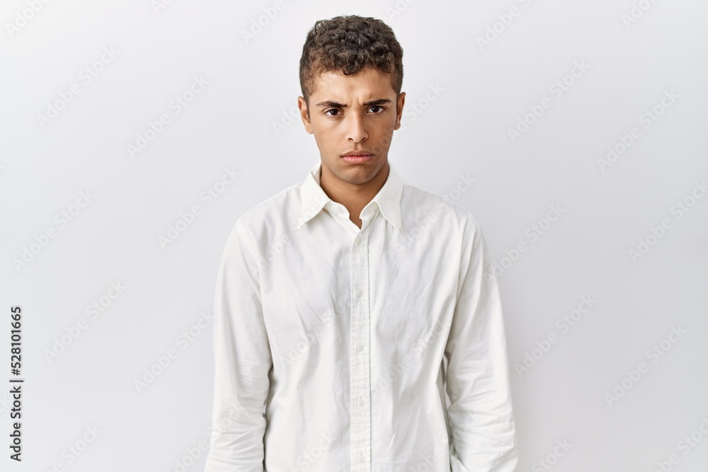Young handsome hispanic man standing over isolated background skeptic and nervous, frowning upset because of problem. negative person. Young handsome hispanic man standing over isolated background skeptic and nervous, frowning upset because of problem. negative person.