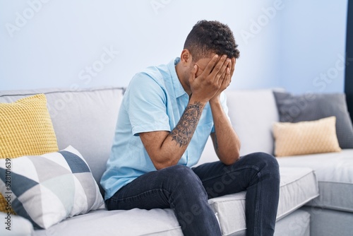 African american man stressed sitting on sofa at home