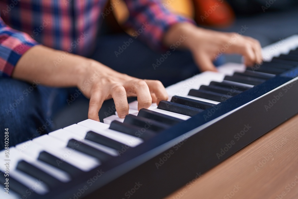 Young man musician playing piano keyboard at music studio Young man musician playing piano keyboard at music studio