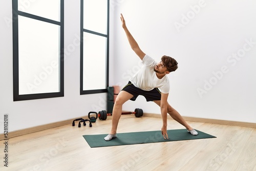 Young arab man training yoga at sport center