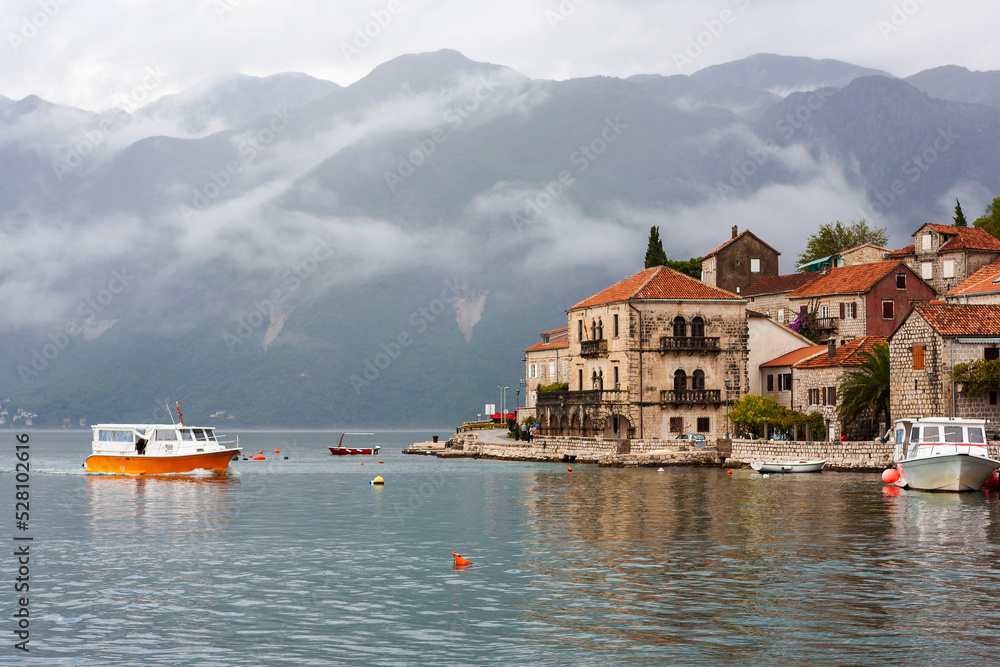 Motor launch approaching the quayside at Perast on the Bay of Kotor, Montenegro, on an overcast day