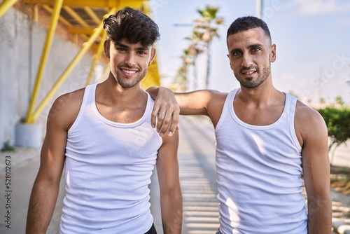 Two hispanic men sporty couple smiling confident standing at street